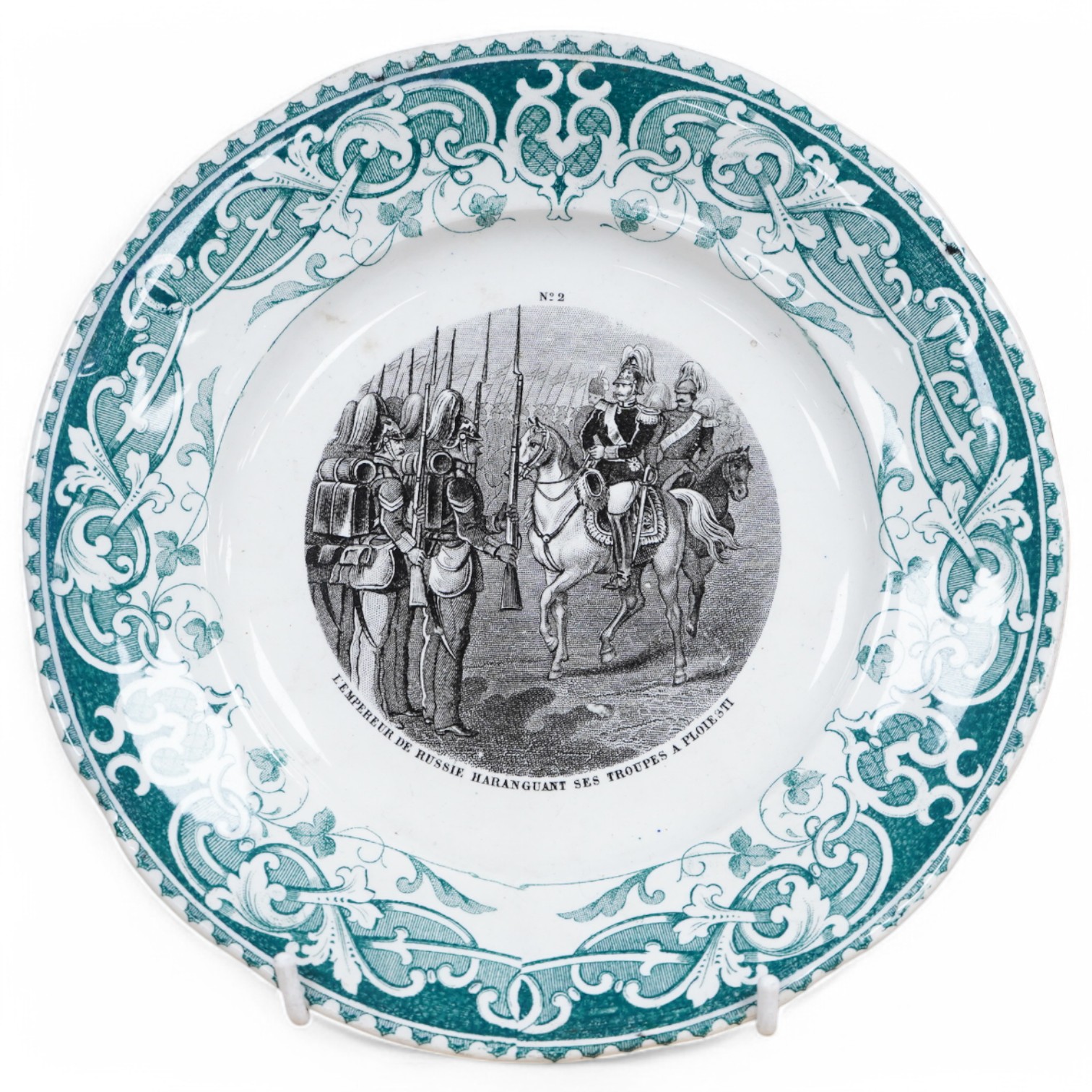 A 19th Century French military commemorative plate, transfer printed with a scene of Russian infantry soldiers, ‘L’Empereur de Russe Haranguant ses Troupes a Ploiesti’ (The Emperor of Russia inspecting his troops in Ploi